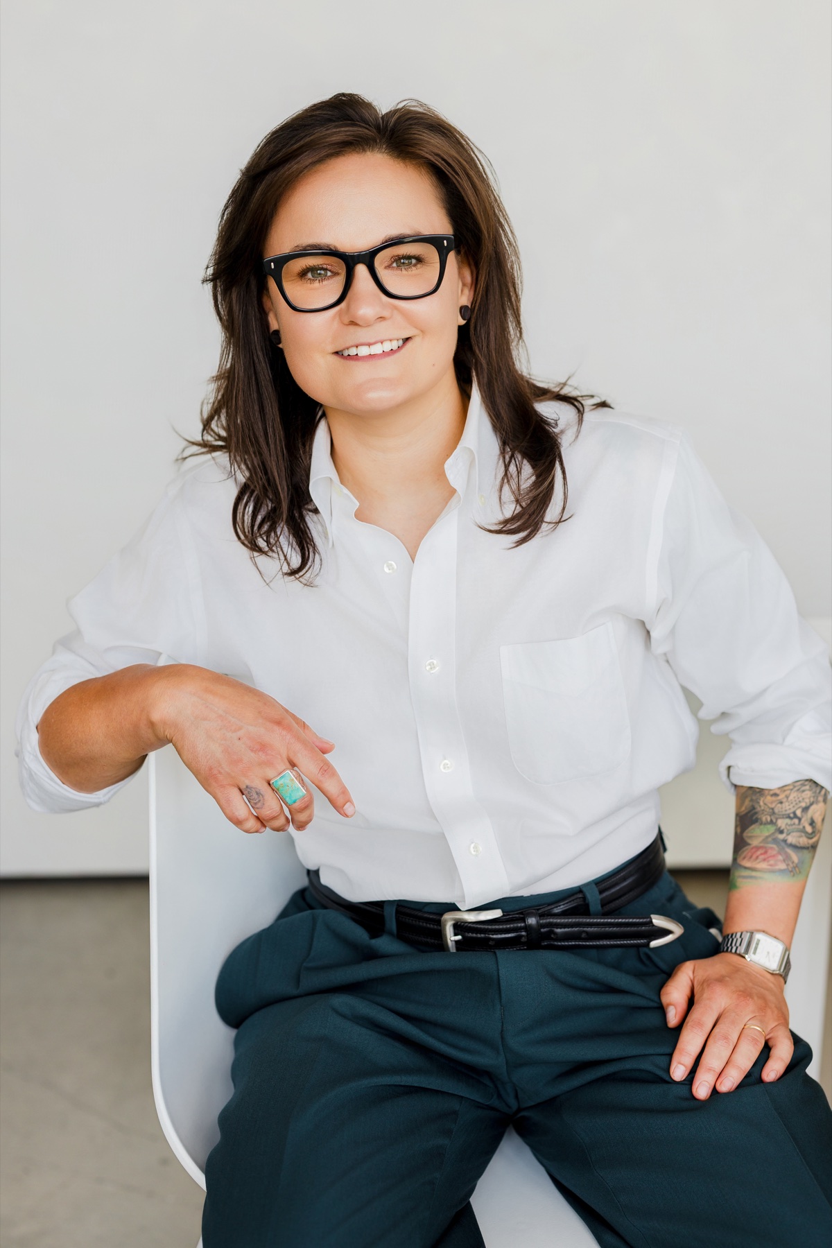 Jessica Ferrell seated in a white shirt and deep teal trousers