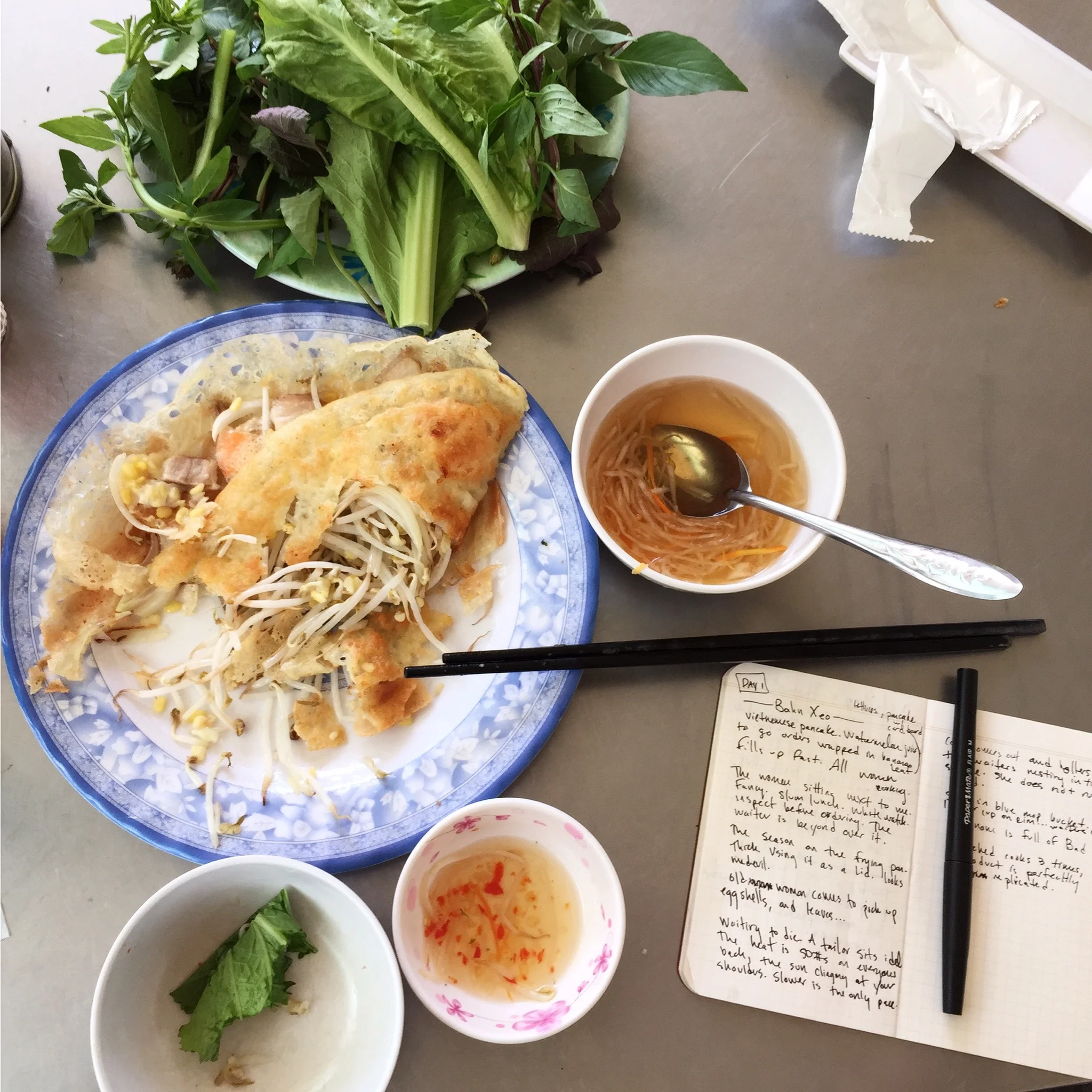 A Vietnamese meal beside a notebook filled with handwritten observations