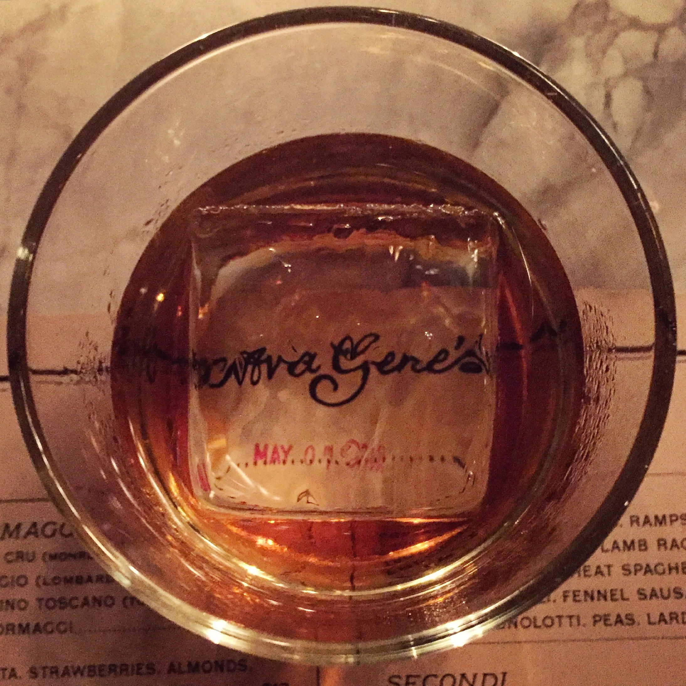 An amber cocktail with Ava Gene’s centered beneath the glass